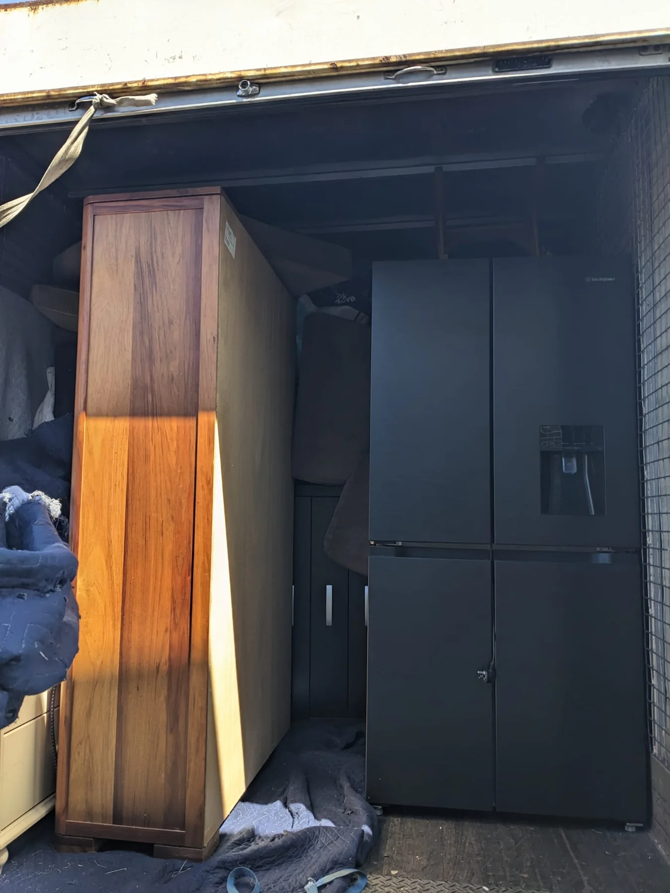 A large fridge being loaded in a moving truck
